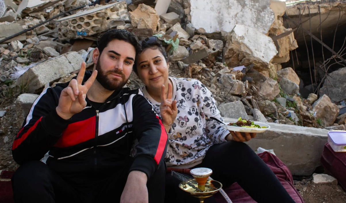 Sitting next to his neighbour Zainab Aqil, Ali Awad points to a pile of shattered cinder blocks behind him, saying: ‘This is my home and this is her home’ (Hanna Davis/MEE)