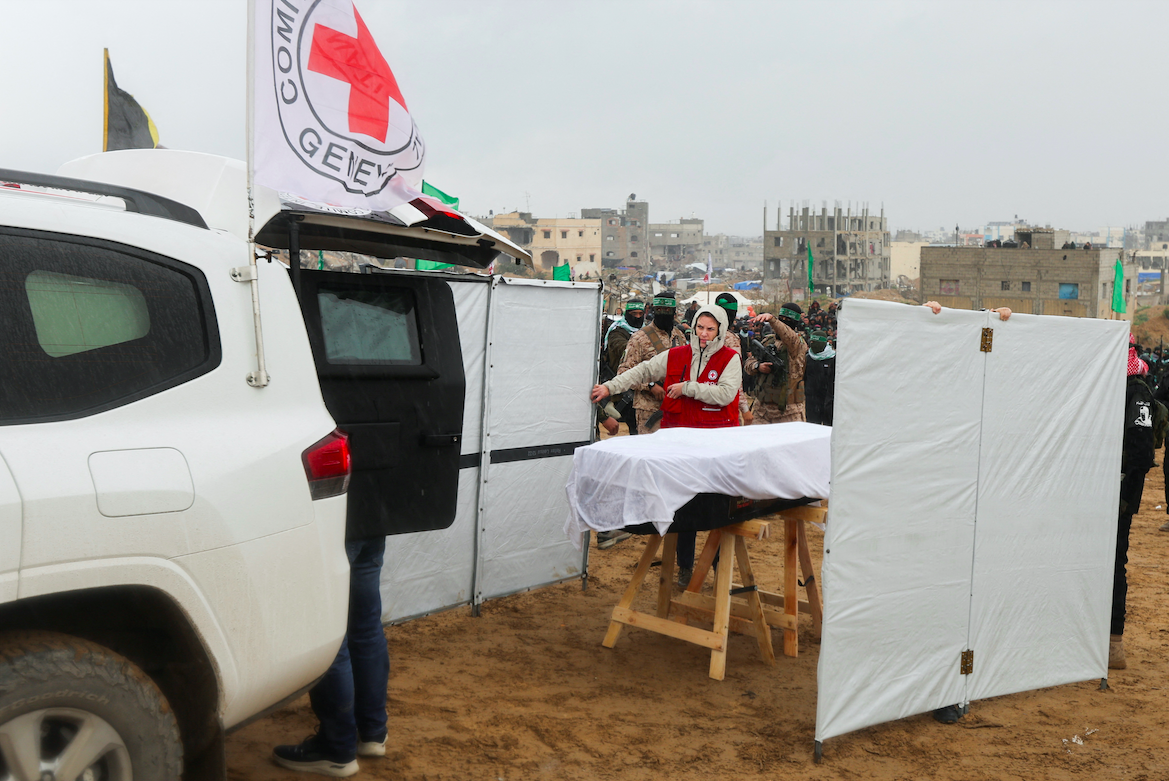 A member of the Red Cross stands near a coffin during the handover of deceased captives Oded Lifschitz, Shiri Bibas and her two children Kfir and Ariel Bibas to the Red Cross, as part of a ceasefire deal. REUTERS/Ramadan Abed