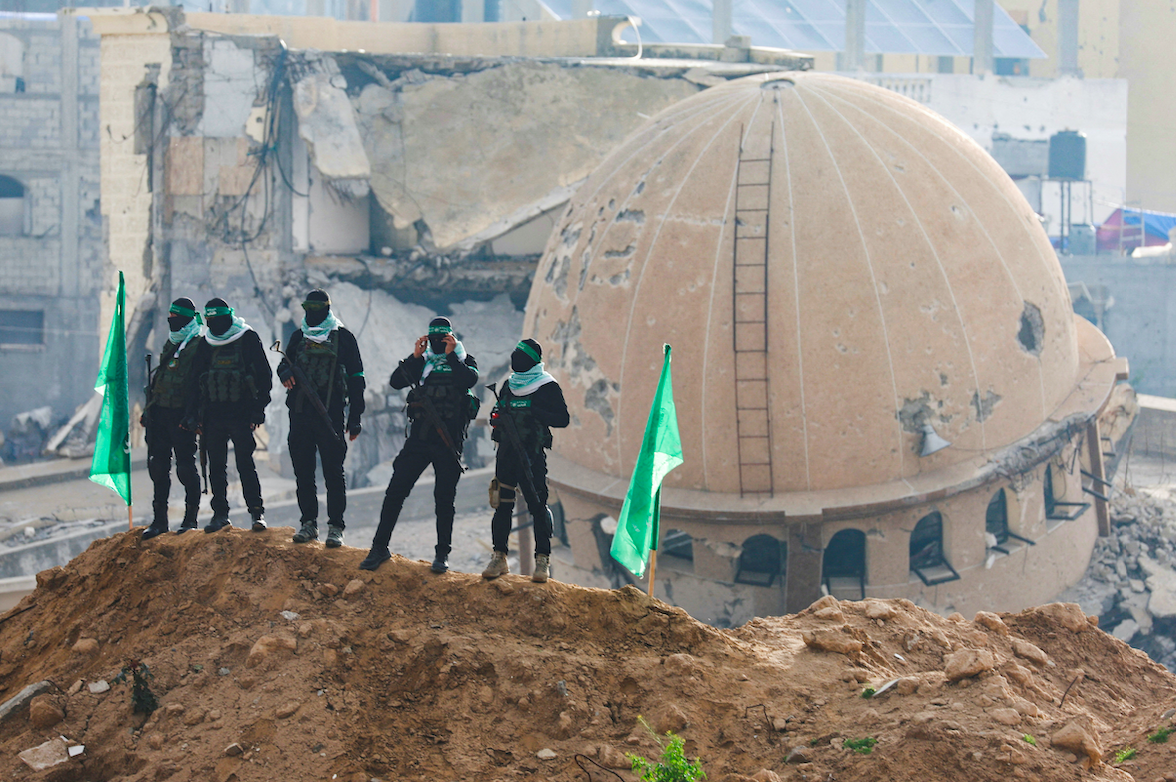 Hamas fighters keep guard on the day Hamas hands over bodies of captives Oded Lifschitz, Shiri Bibas and her two children Kfir and Ariel Bibas to the Red Cross. (REUTERS/Ramadan Abed) 