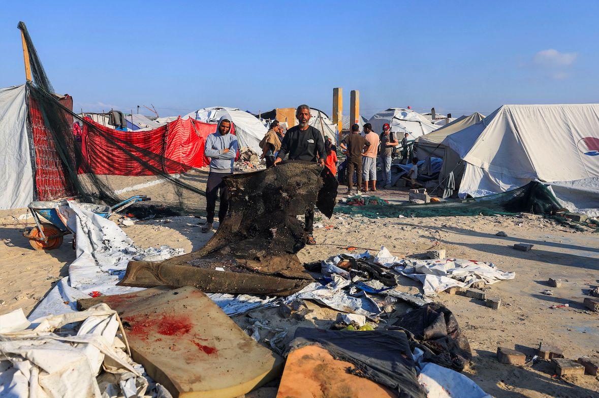 Palestinians inspect the damage at the site of an Israeli airstrike on a tent sheltering displaced people at the Gaza seaport, in Gaza City, June 4, 2025. REUTERS