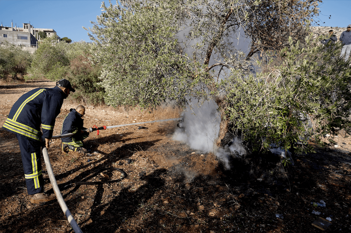 People look at a burnt vehicle at the site where Israeli forces killed three Palestinians, near Jenin, in the Israeli occupied West Bank October 28, 2025. REUTERS
