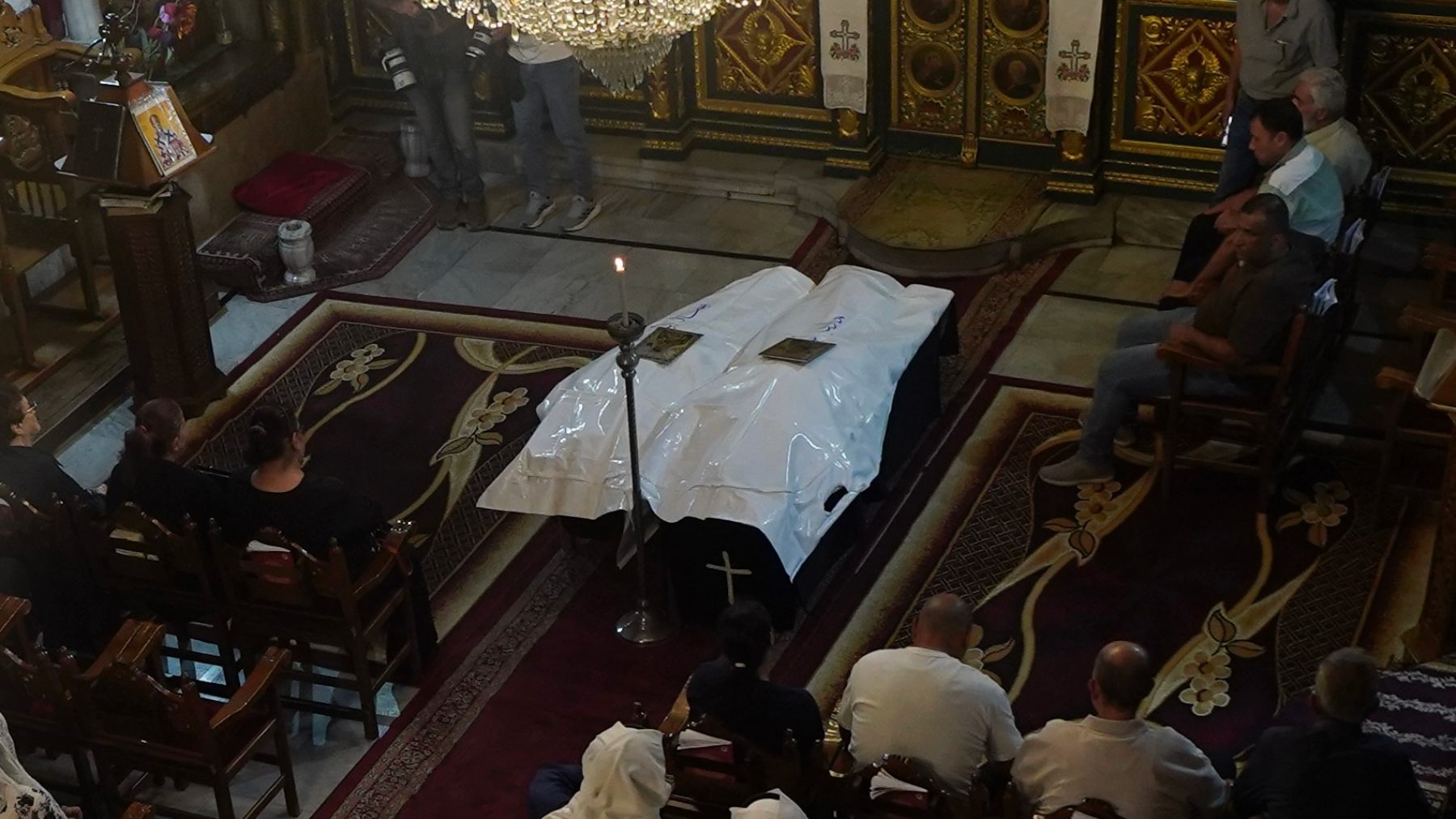 Shrouded bodies of Mary Abu Dawud and her mother Maysaa lie at St Porphyrius Church in Gaza City during funeral prayers attended by relatives and members of Gaza’s Christian community (Middle East Eye)