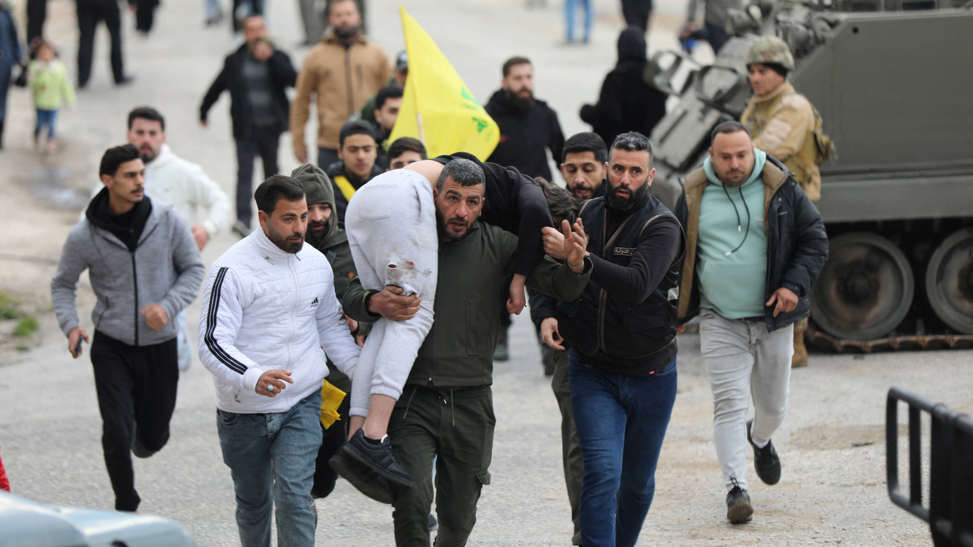 A man carries a wounded person in Burj al-Muluk, near the southern Lebanese village of Kfar Kila, where Israeli forces remained on the ground after a deadline for their withdrawal passed (Reuters)