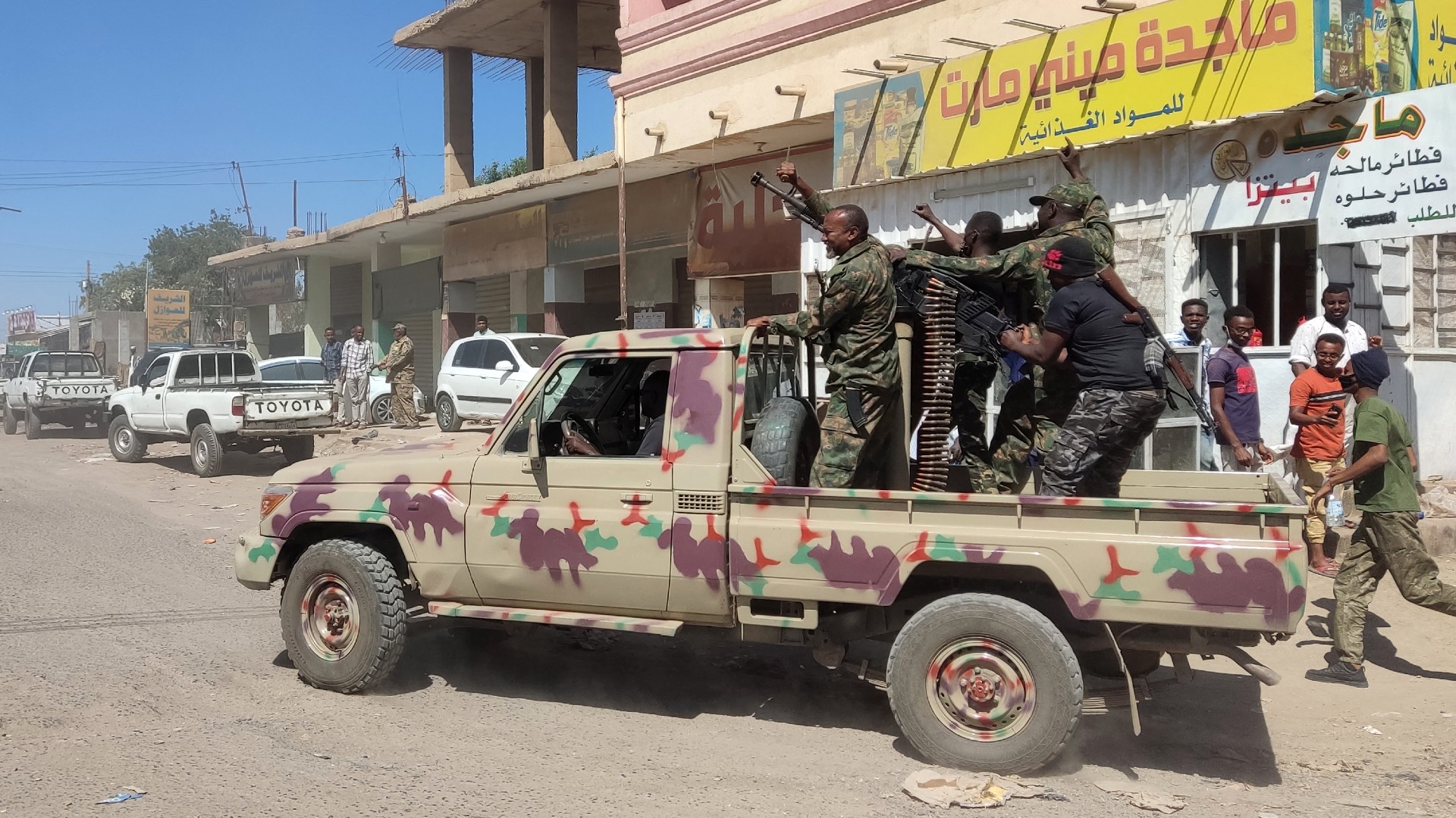 Sudanese soldiers and personnel drive a pick up truck mounted with a machine gun on a street in Gedaref city, Sudan, 14 January (AFP)