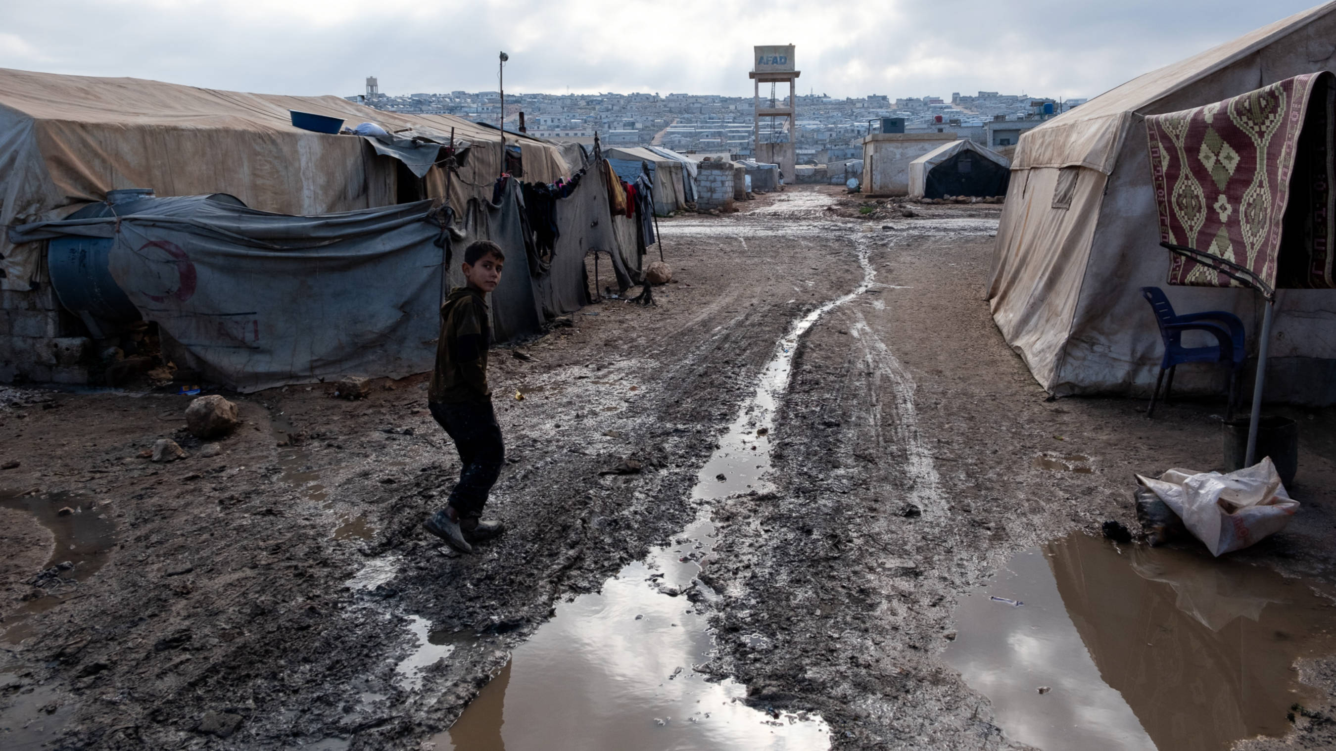 A child walks through Amal displacement camp in northern Syria, 31 December 2024 (Andrew Waller/MEE)