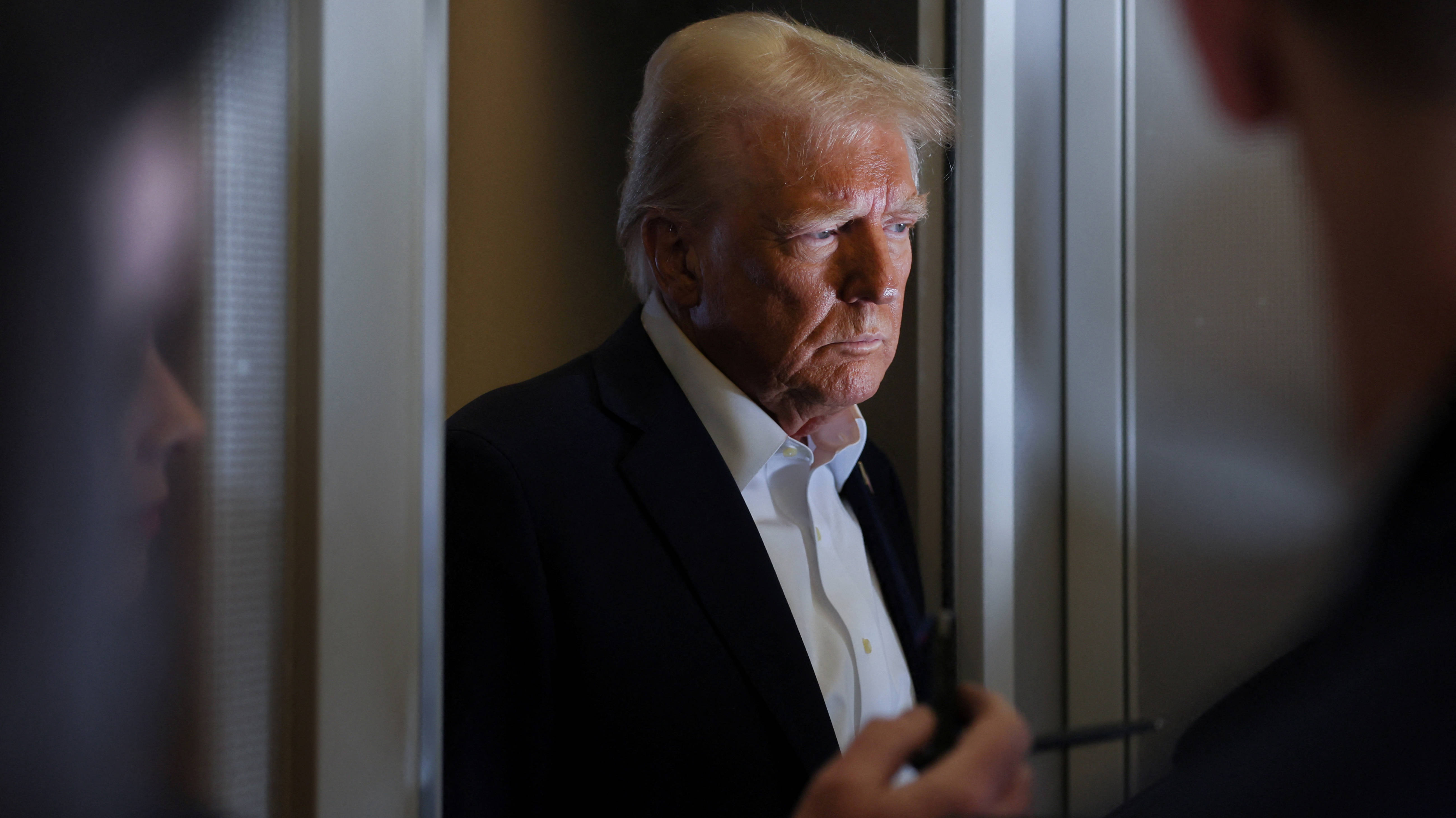 US President Donald Trump listens to reporters’ questions aboard Air Force One on 25 January 2025 (Reuters)