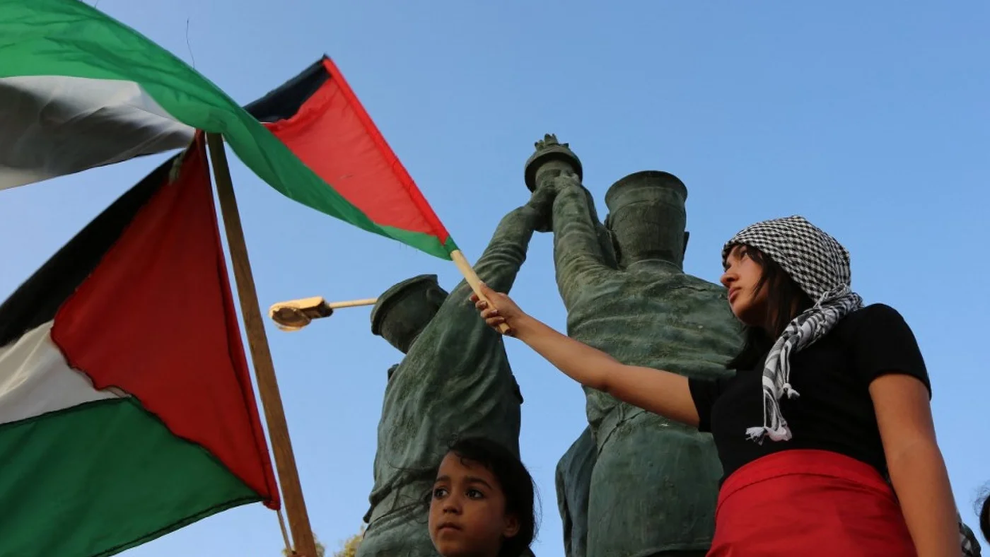 Tunisian youths wave Palestinian flags as they welcome the Sumoud convoy, Tunis, 9 June (AFP)
