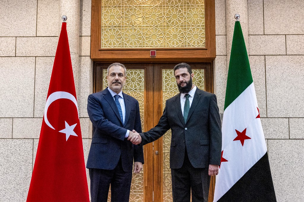 Turkey's Foreign Minister Hakan Fidan (L) meets Hay'at Tahrir al-Sham (HTS) leader Ahmed al-Sharaa in Damascus on 22 December 2024 (Turkish Foreign Ministry/AFP)