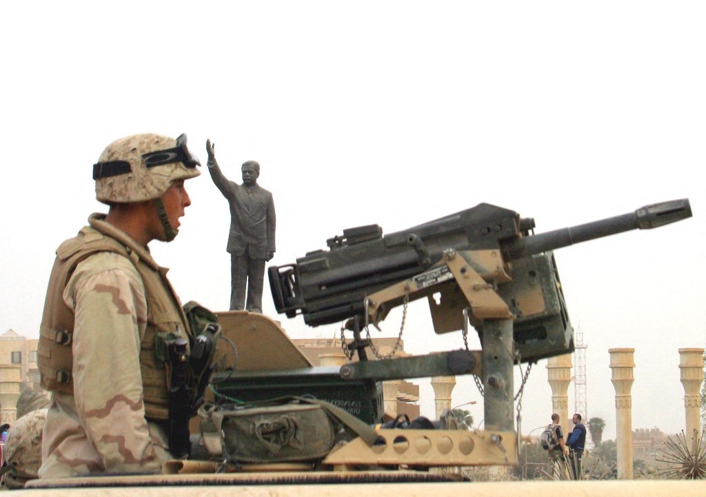 US soldiers guard an area in the centre of Baghdad, 9 April 2003. The statue of Iraqi leader Saddam Hussein in the background was later toppled amid raucous celebrations (AFP)