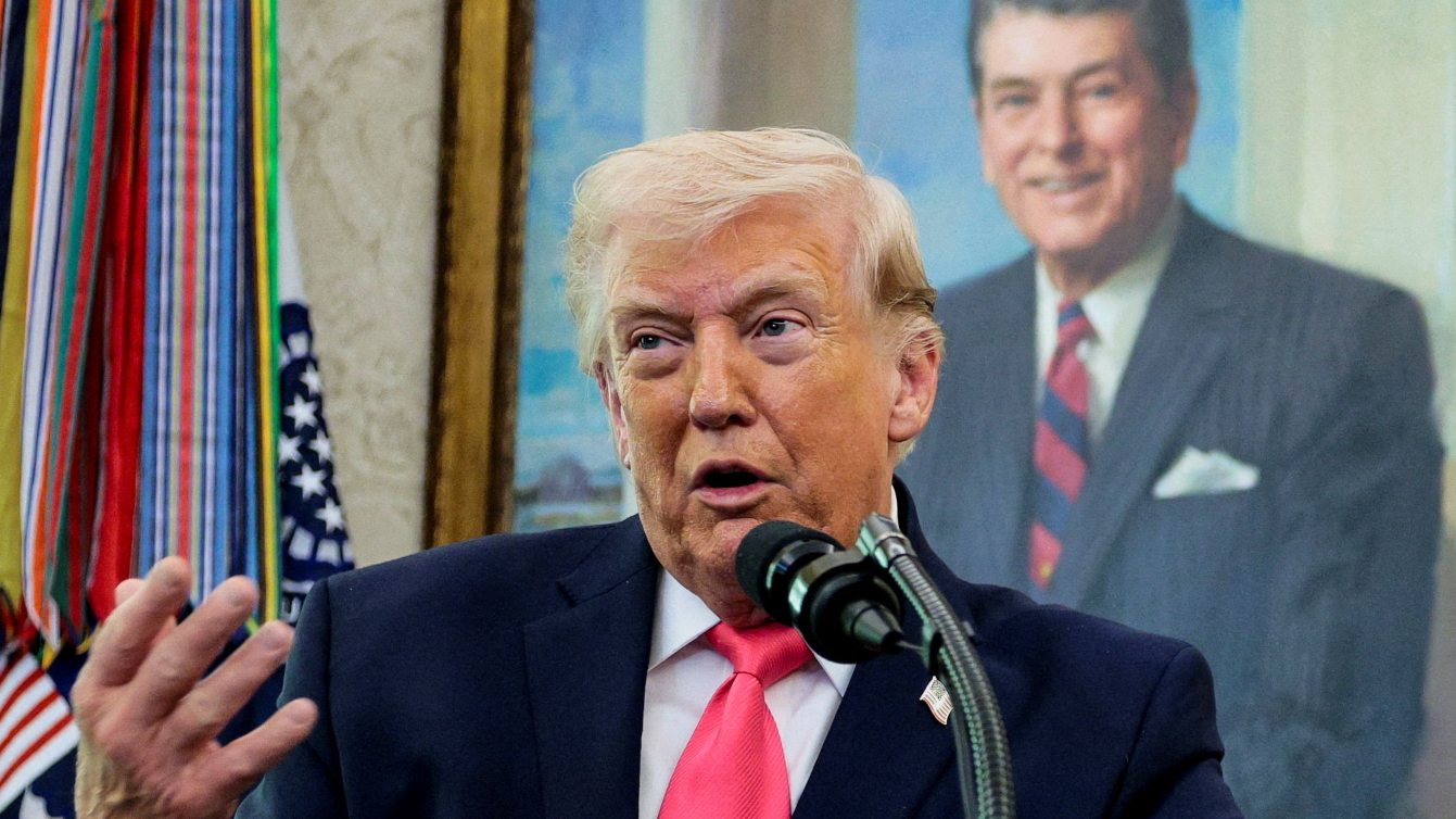 U.S. President Donald Trump speaks, with a portrait of former U.S. President Ronald Reagan in the background, as he attends Markwayne Mullin's swearing-in as Department of Homeland Security (DHS) Secretary, at the White House in Washington, D.C., U.S., March 24, 2026. REUTERS/Evan Vucci TPX IMAGES OF THE DAY