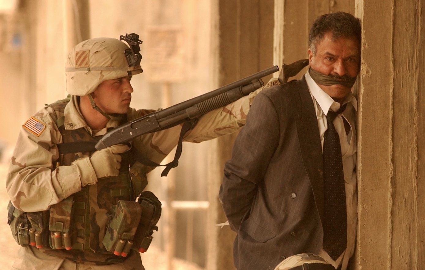 A US Marine puts a shotgun to the head of a man arrested following a street brawl in Karrada, Baghdad, in April 2003 (Peter Nicholls/The Times)