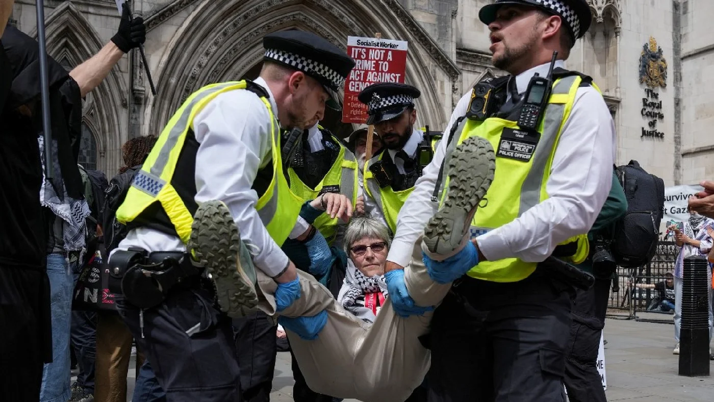 Police remove protesters from outside the Royal Courts of Justice in central London on 15 June 2026 (AFP)