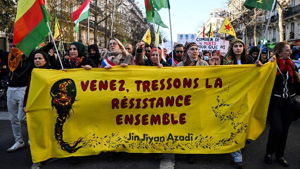 Protesters hold a banner reading 