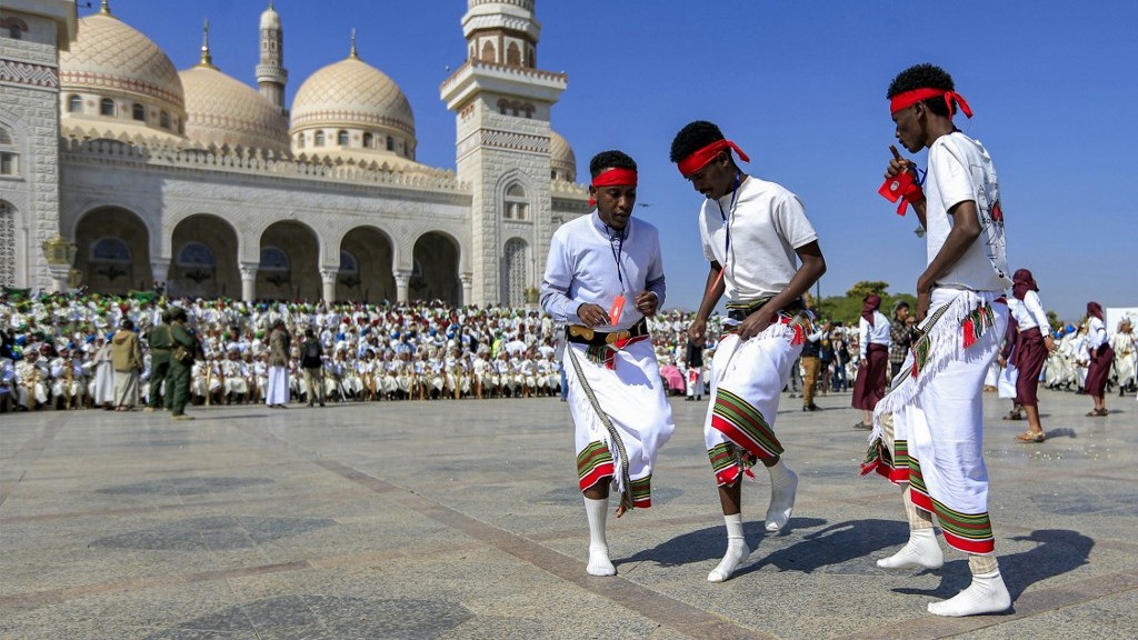 Men of Ethiopian origin dance in a mass wedding for over four thousand couples organised by the Zakat authority in the capital Sanaa on 31 October 2022 (AFP)