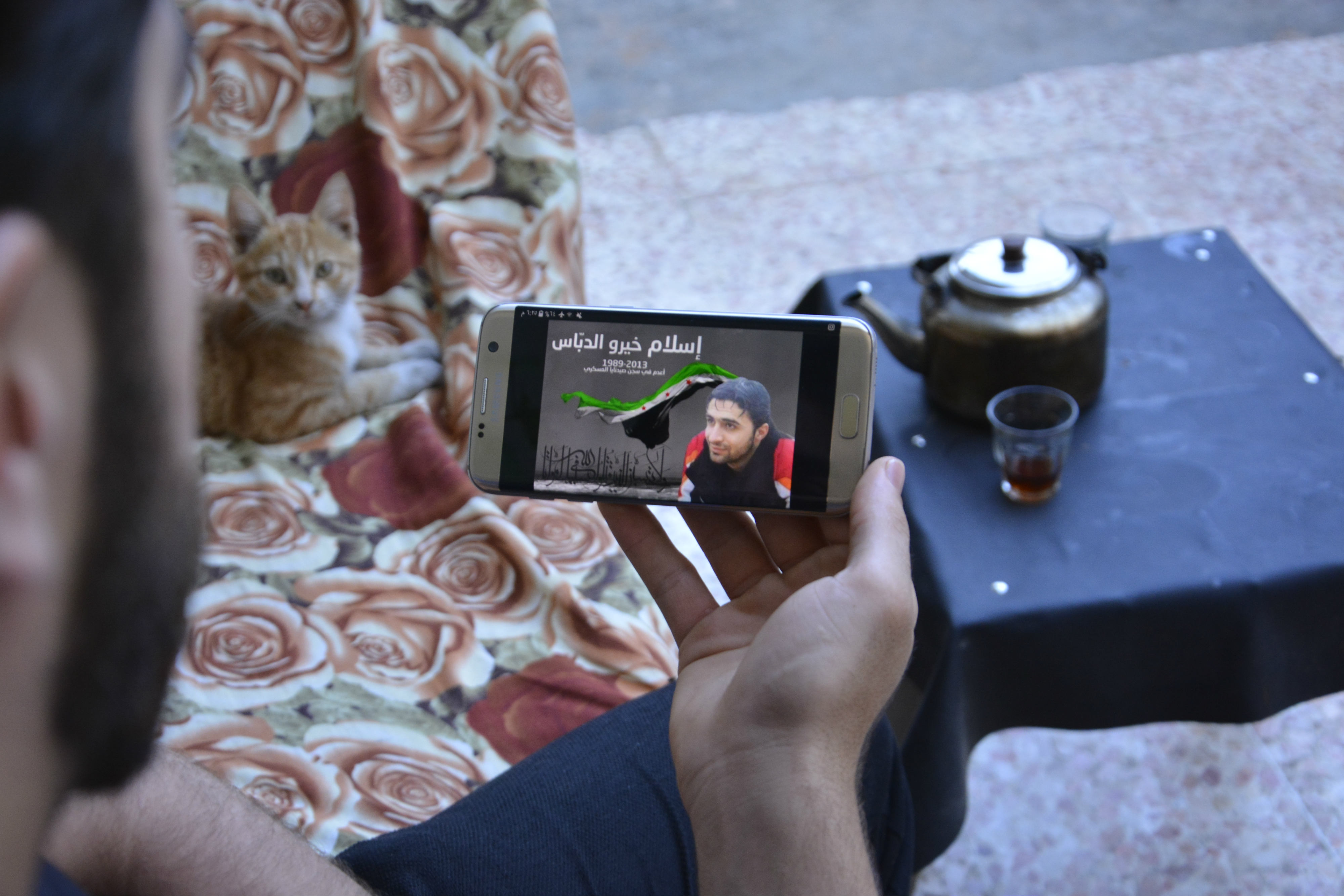 Dabbas looks at an image of his cousin Khairou, who died in detention (MEE/Harun al-Aswad)