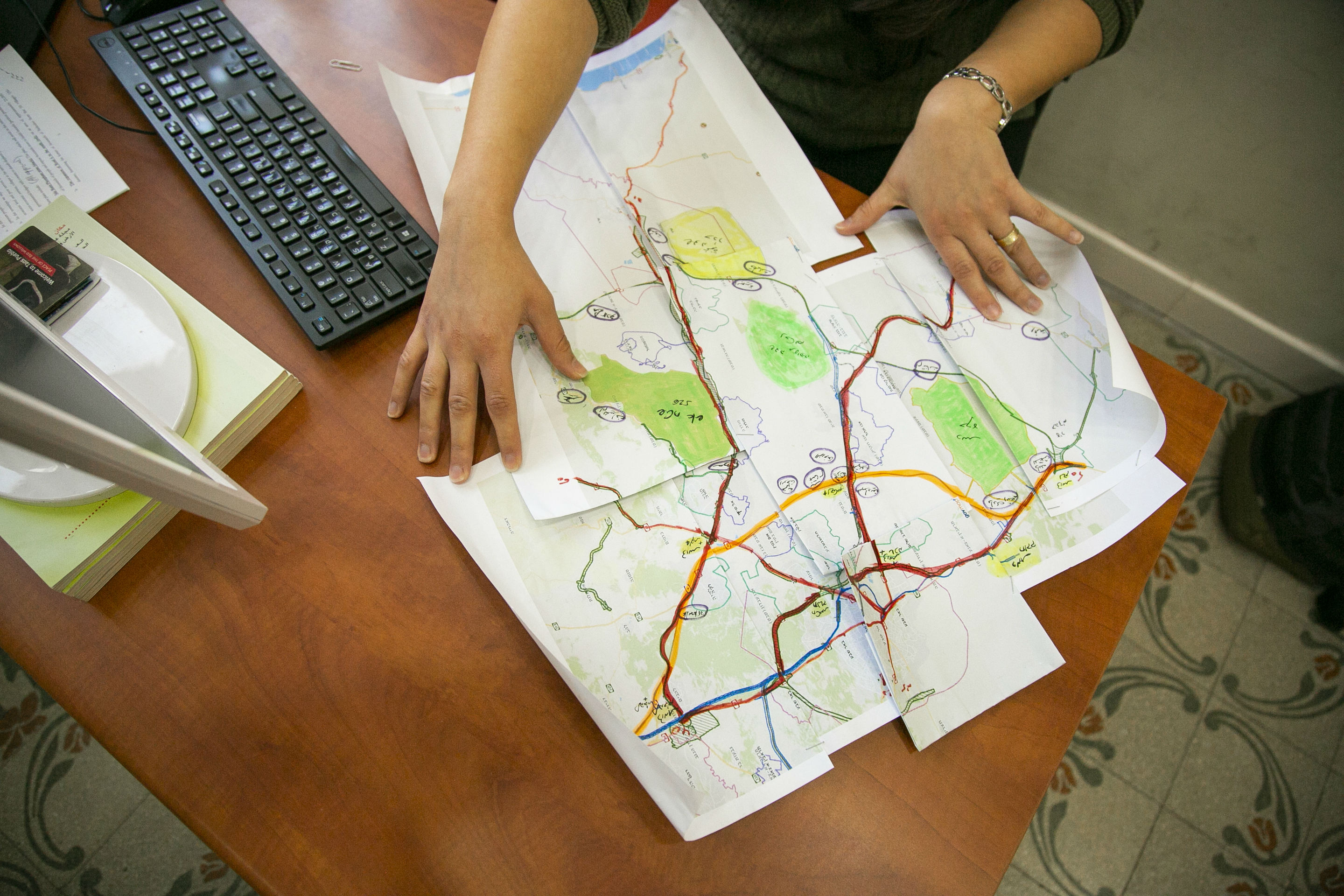 Myssana Morany stretches out a map she made manually because the unrecognised villages aren't listed on other maps (MEE/Jack Dodson)