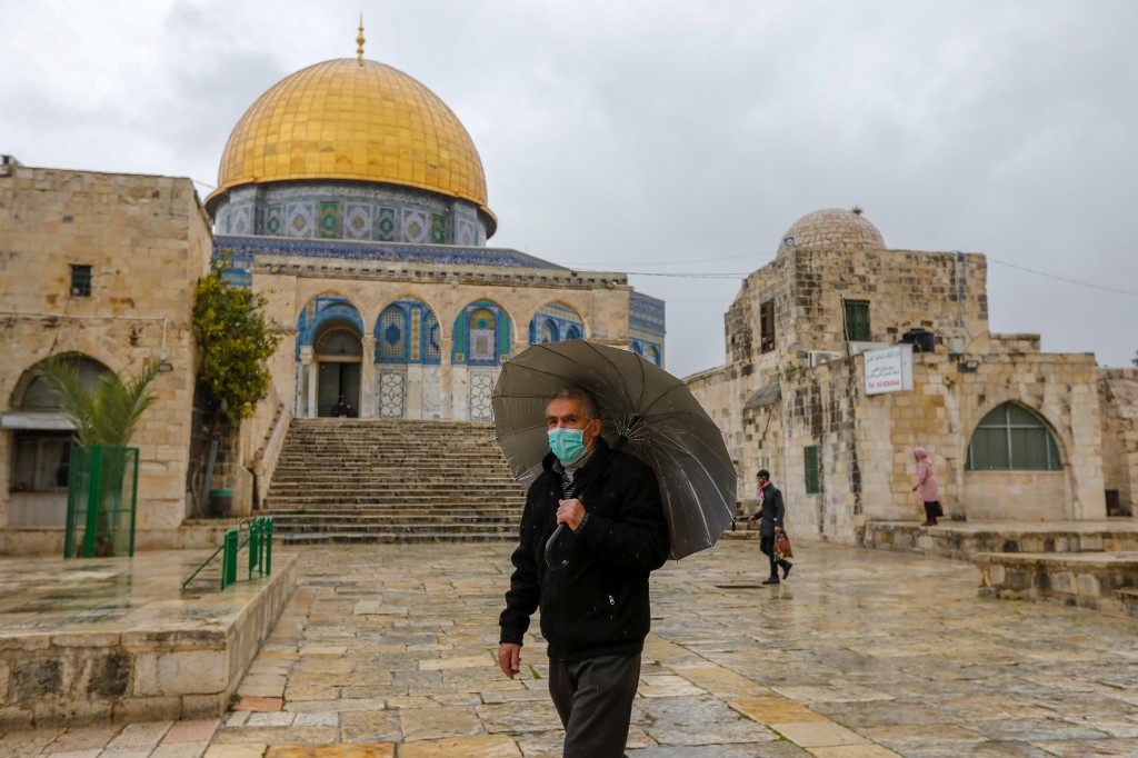 A man wears a face mask to protect against coronavirus inside the almost-deserted al-Aqsa Mosque compound in Jerusalem on 20 March (AFP)