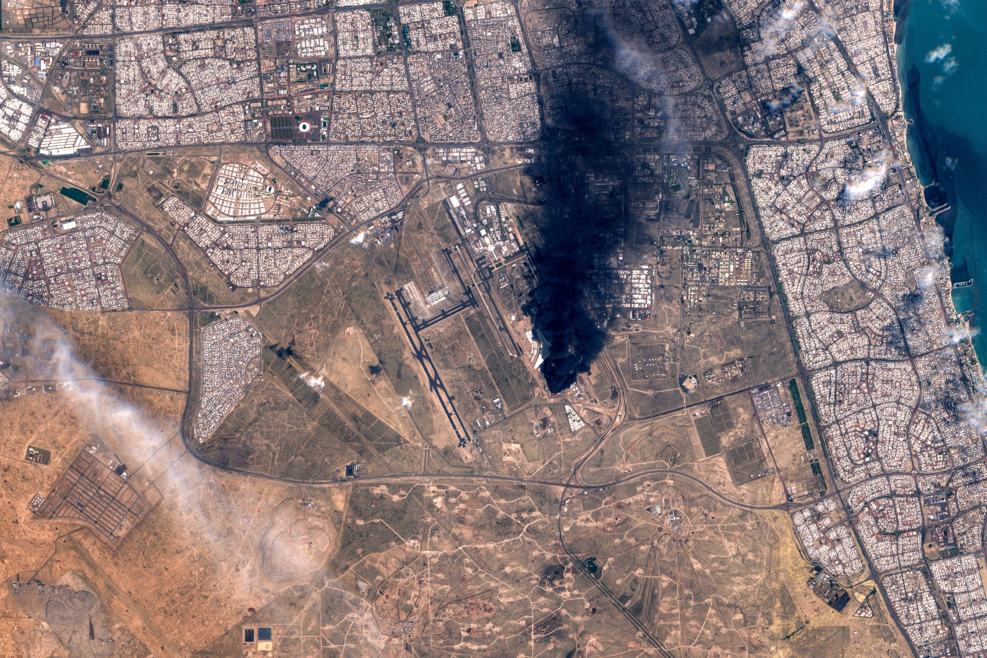 Satellite imagery shows smoke plumes billowing in the vicinity Kuwait International Airport on 25 March 2026 (European Space Agency/AFP)