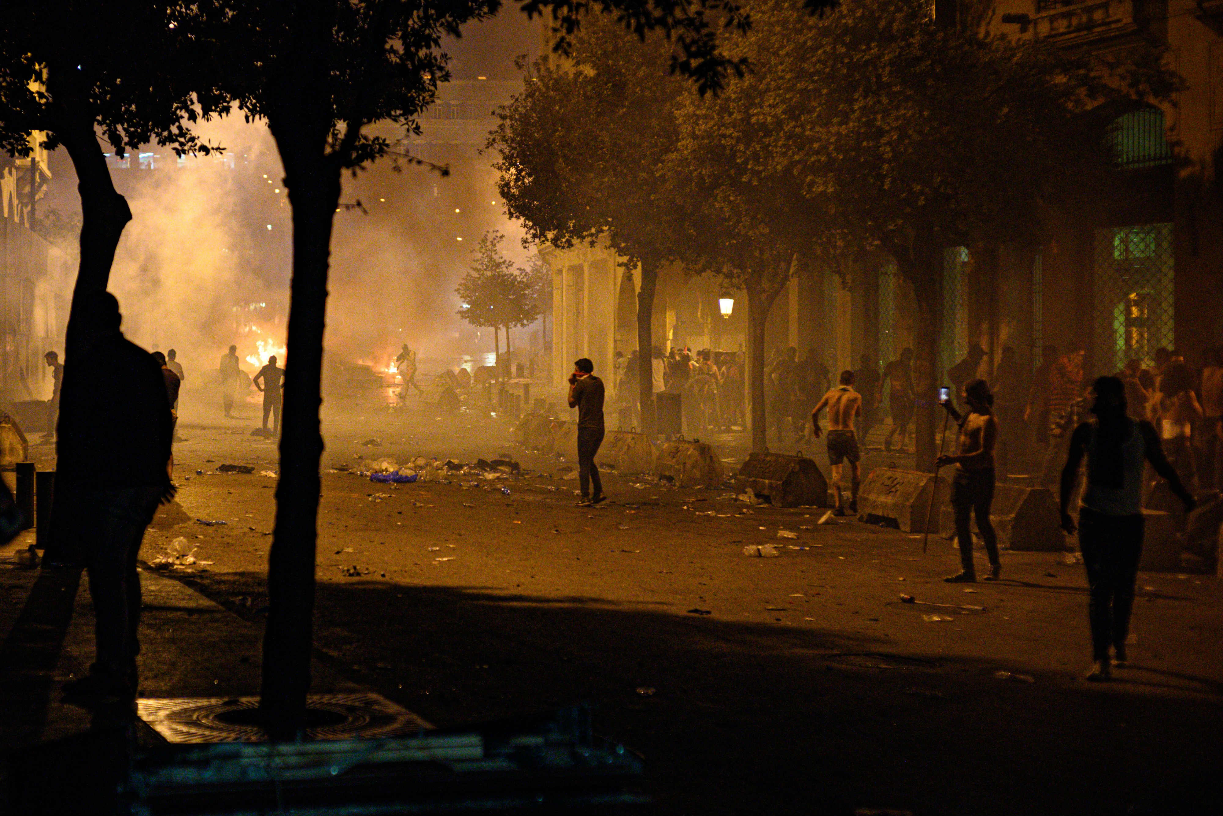 Des manifestants bravent les gaz lacrymogènes tirés par les forces de sécurité sur la place Riad al-Solh à Beyrouth vendredi soir (MEE/Finbar Anderson)