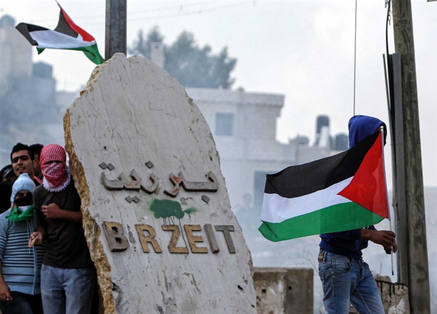 Des étudiants lancent des pierres sur des soldats israéliens au check-point d’Atara en novembre 2012 (AFP)