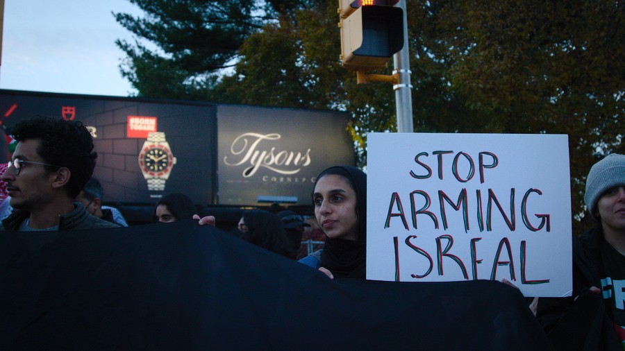 A pro-Palestinian demonstrator holds up a poster reading 