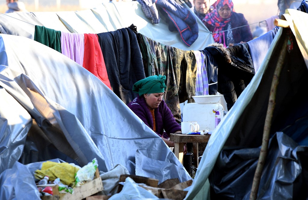 Migrants are seen at an improvised camp on the border town of Velika Kladusa in Bosnia and Herzegovina on 15 October 2021 (AFP)