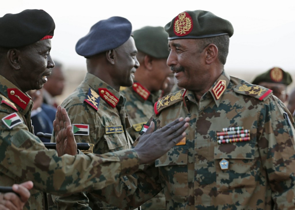 General Abdel Fattah al-Burhan greets military officers on the outskirts of Khartoum on 30 October (AFP)
