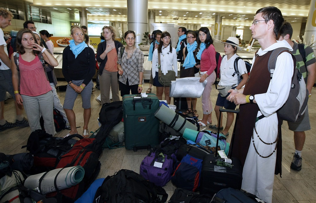 Des étudiants catholiques français écoutent un prêtre à leur arrivée à l’aéroport international Ben Gourion le 22 juillet 2009 (AFP)