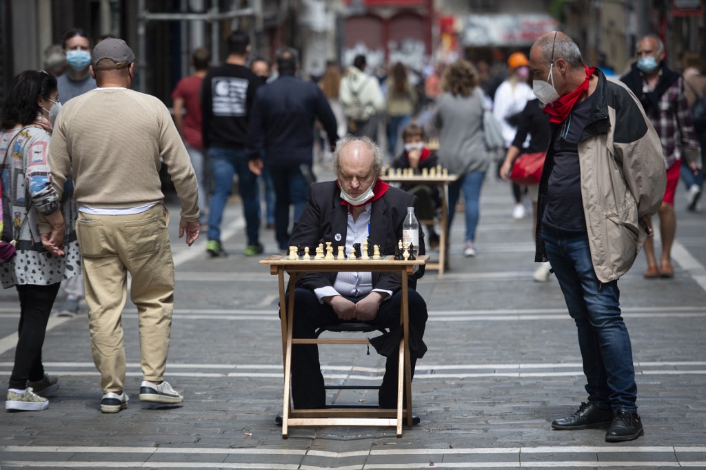 Two men ponder over a chessboard in Estafeta street in Pamplona during the 