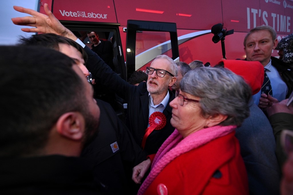Jeremy Corbyn talks with a man about Palestine while campaigning for the general election in northern England on 11 December (AFP)