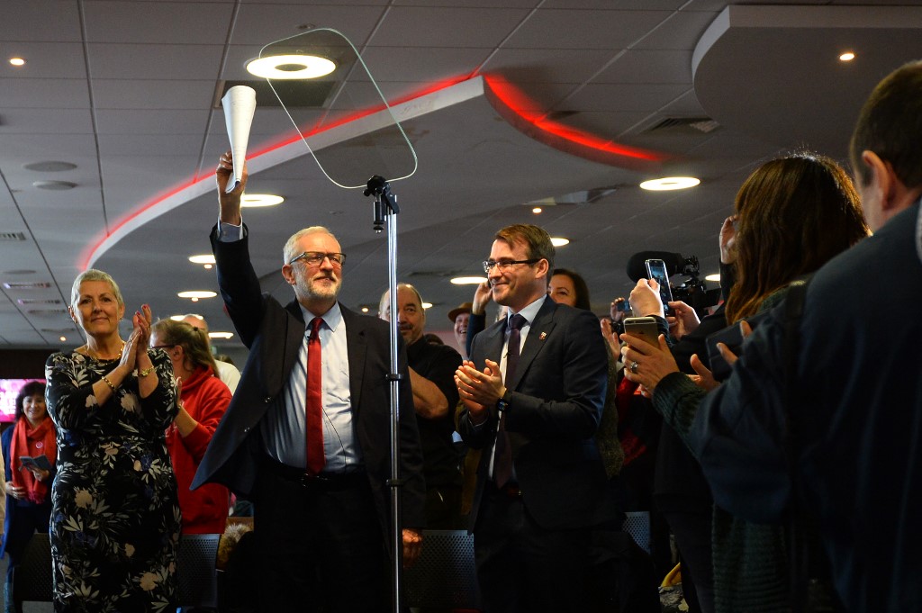 Corbyn waves to supporters at a campaign stop in southwestern England on 28 November (AFP)