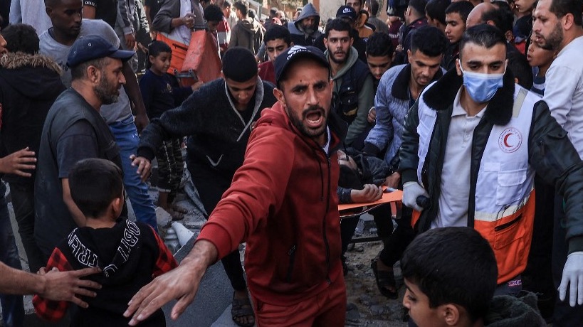 A Palestinian medic and civilians carry an injured man after an Israeli strike on Rafah, in the southern Gaza Strip on November 23, 2023 (AFP)