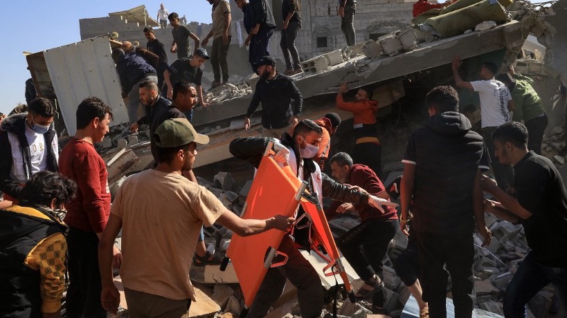 A Palestinian medic and civilians carry an injured man after an Israeli strike on Rafah, in the southern Gaza Strip on November 23, 2023