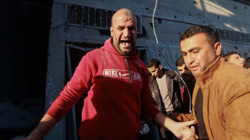 A wounded man is helped out of a bombarded area during Israeli air strikes on the Rafah refugee camp in the southern Gaza Strip on December 1, 2023,