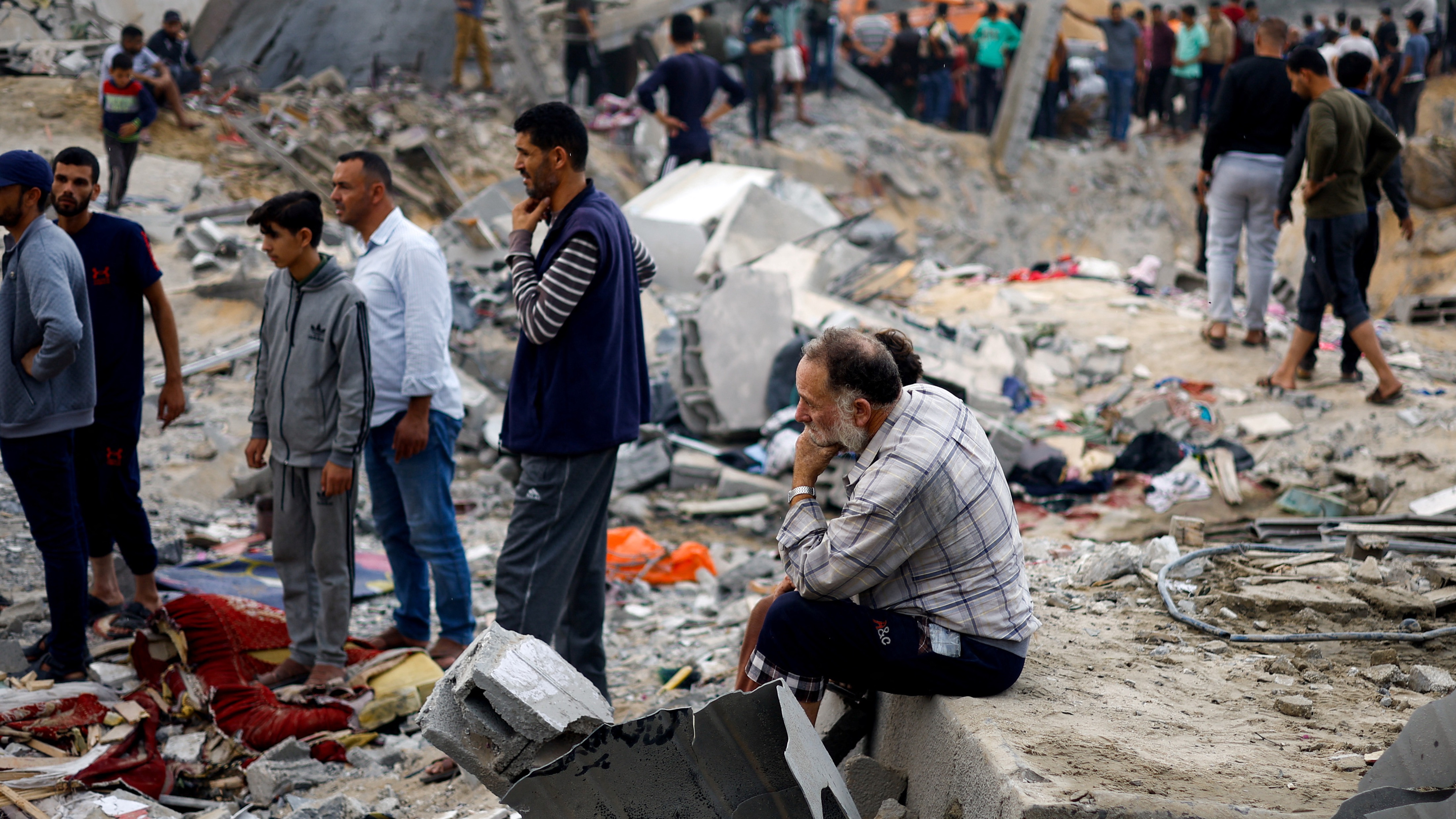 Palestinians gather at the site of an Israeli strike, in Khan Younis (Reuters)