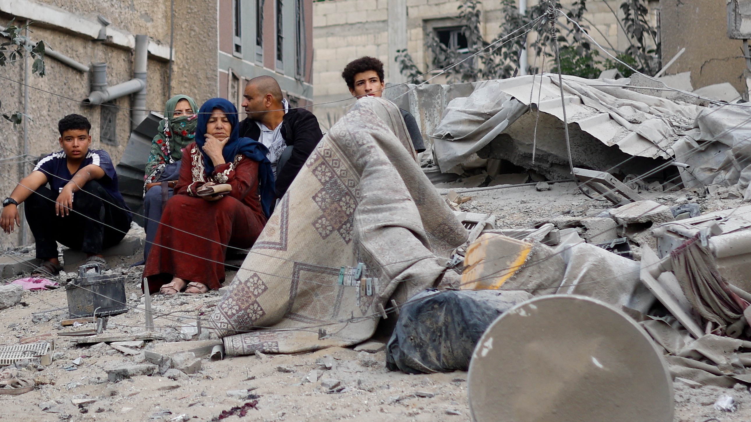 Palestinians gather at the site of an Israeli strike, in Khan Younis (Reuters)