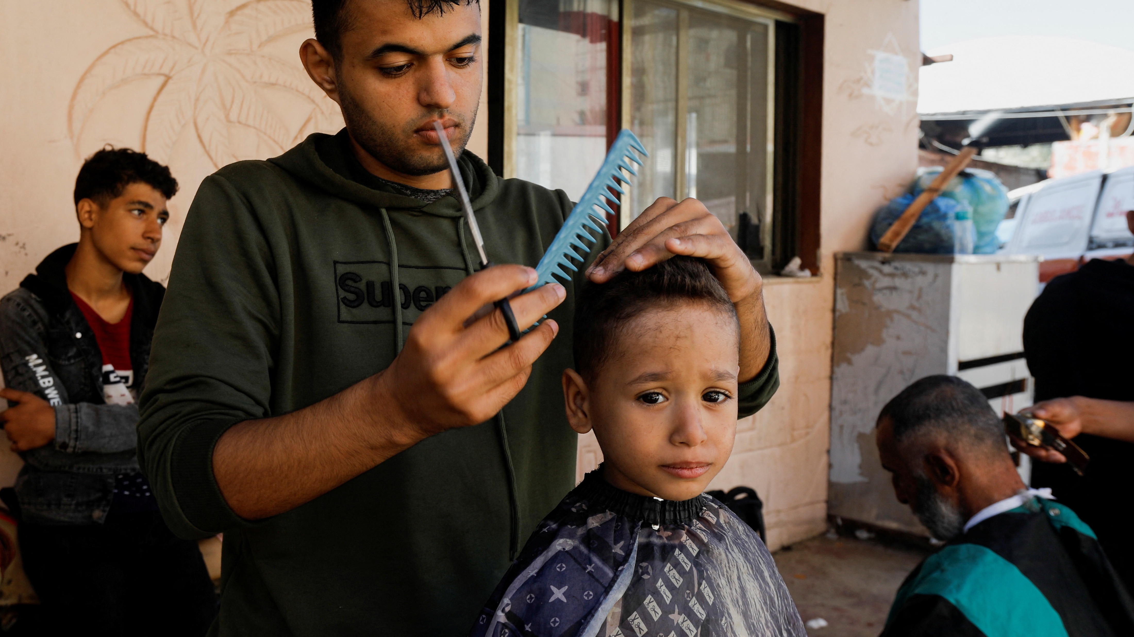 Palestinians have their hair cut during a temporary truce between Hamas and Israel, at Nasser hospital in Khan Younis in the southern Gaza Strip, November 24, 2023. (REUTERS/Saleh Salem) 