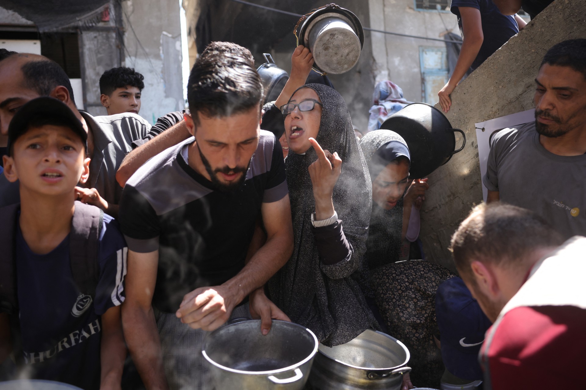 Palestinians line up to receive a hot meal at a food distribution point in Gaza City on 27 June 2025 (AFP/Bashar Taleb)