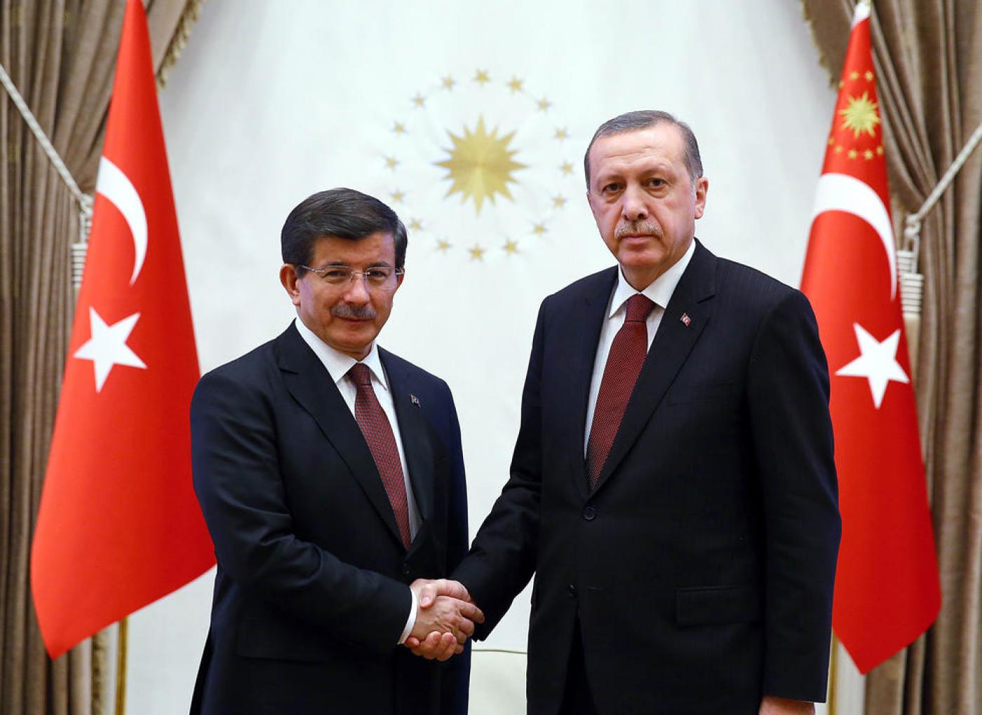 Turkish President Recep Tayyip Erdogan (R) shaking hands with Turkish Prime Minister Ahmet Davutoglu at Presidential Palace in Ankara on 29 January, 2015 (AFP/TURKISH PRESIDENTIAL PRESS OFFICE)