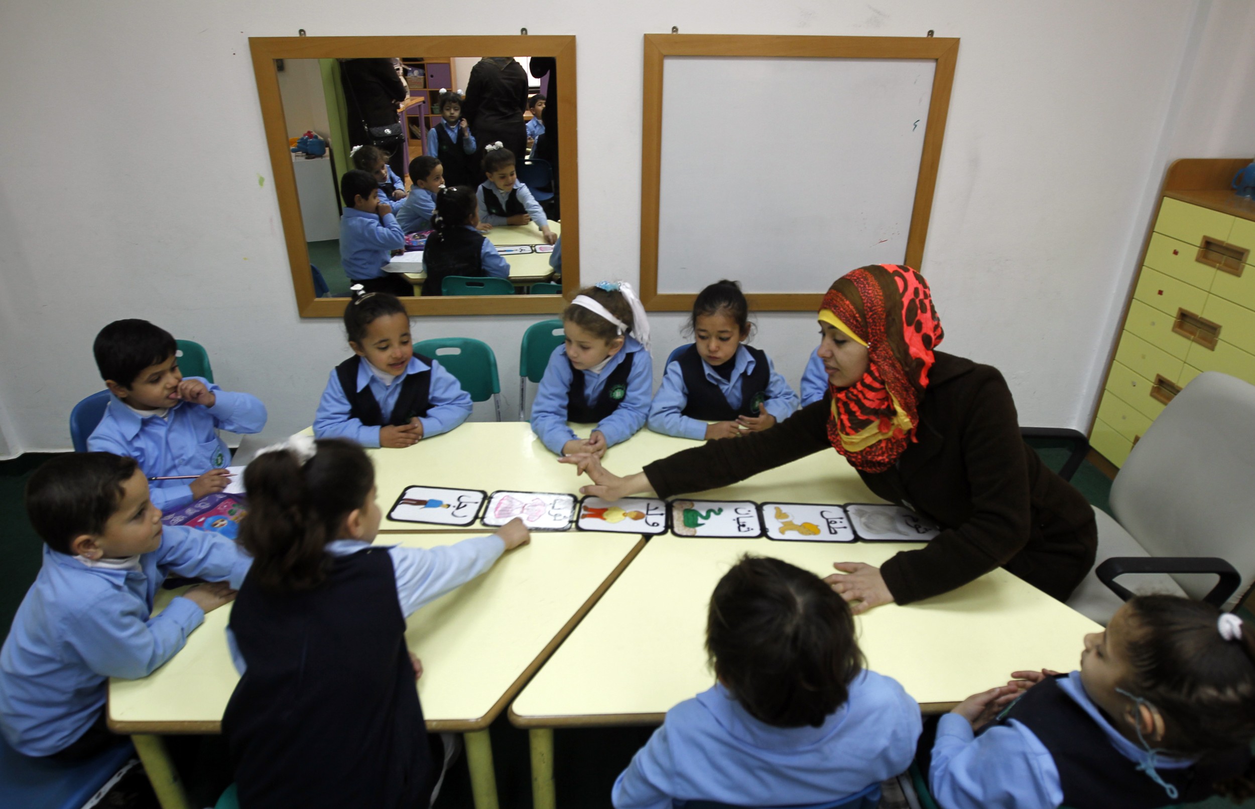 A deaf Palestinian woman teaches hearing impaired children at Atfaluna Society for Deaf Children in Gaza City, on 7 March 2013 (AFP)