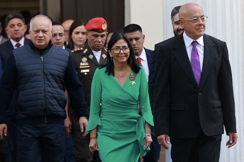 This handout picture released by the Miraflores Palace press office shows Venezuela's interim President Delcy Rodriguez (C); Venezuela's minister of interior, Diosdado Cabello (L); and Venezuela's National Assembly president, Jorge Rodriguez (R), walking after she took an oath in a ceremony at the National Assembly in Caracas on January 5, 2026.