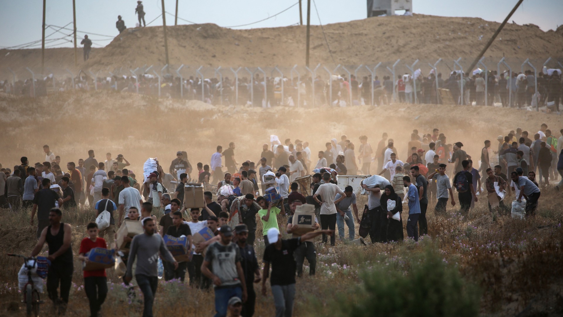 eople carry relief supplies from the Gaza Humanitarian Foundation (GHF), a private US-backed aid group that has bypassed the longstanding UN-led system in the territory, as displaced Palestinians return from an aid distribution centre in the central Gaza Strip on June 8, 2025. 