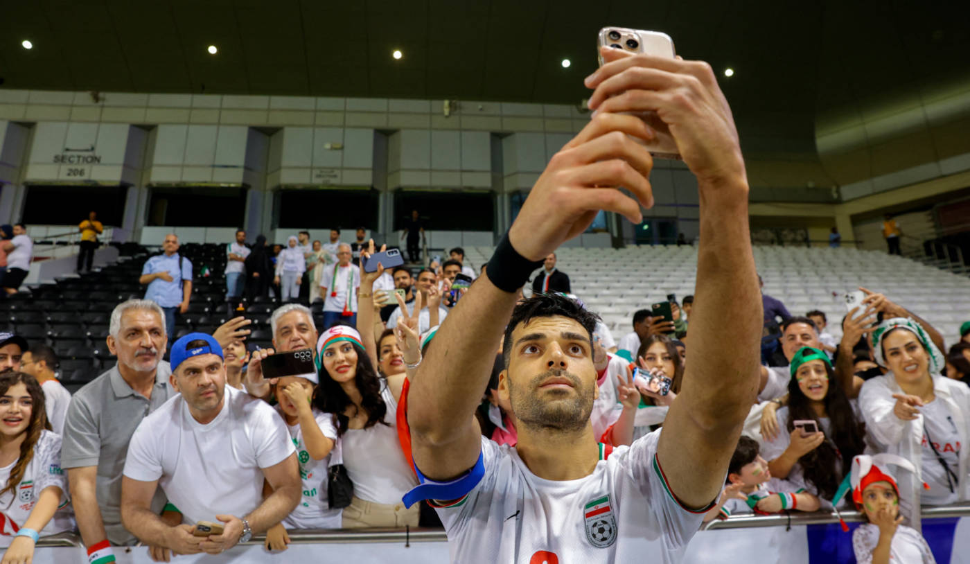 Iran's Mehdi Taremi takes a selfie with fans at  the 2026 FIFA World Cup Asian Qualifier between Qatar and Iran in Doha on 5  June 2025 (AFP)