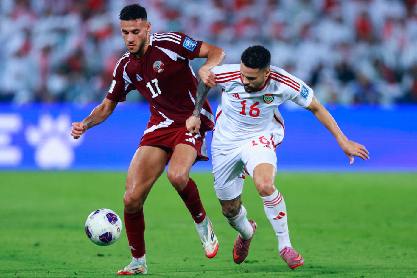 Qatar's Mohamed Al-Mannai fights for the ball with UAE's Marcus Meloni during the FIFA World Cup 2026 Asian qualifier football match in Doha on 14 October 2025 (AFP)