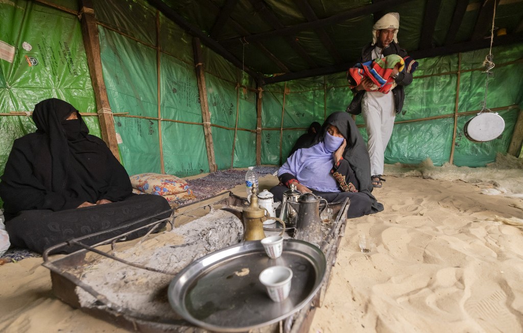 An Egyptian bedouin family sit around a fire pit at their home in al-Rawda village near el-Arish city, in the northern Sinai Peninsula, on March 20, 2022.
