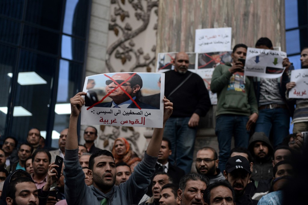 Egyptian protesters hold up a portrait of Sisi in Cairo on 7 December 2017 (AFP)