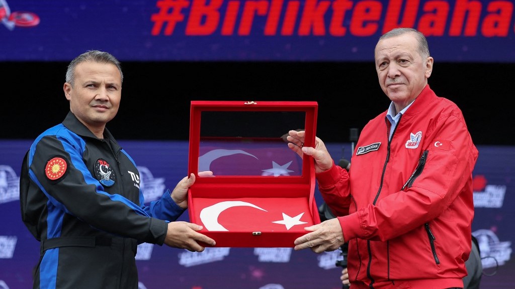 Turkish President Recep Tayip Erdogan presenting a flag to Turkey's first astronaut Alper Gezeravci (AFP)