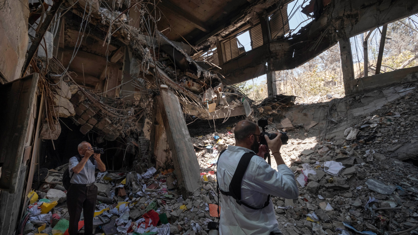 Iranian press photographers take photos of an office building of the Evin prison, which is destroyed in Israeli strikes in northern Tehran, 1July 2025 (Reuters)