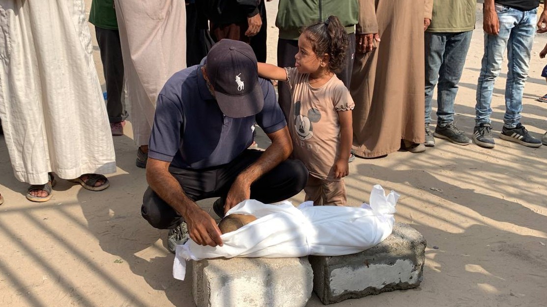 Abd al-Salaam Abu Mohsen’s father is seen mourning his son, while his daughter comforts him (MEE/Ahmed Aziz)