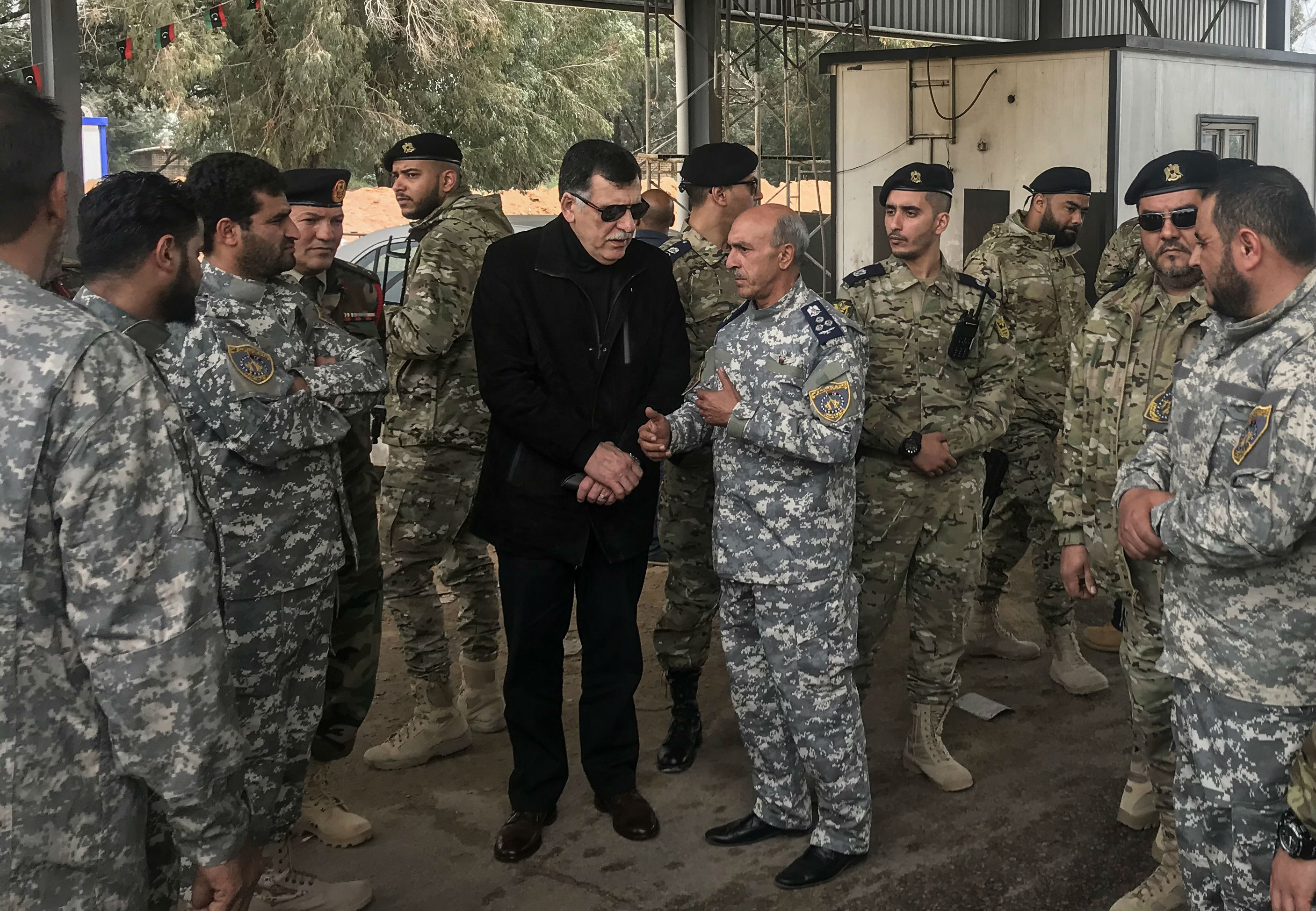 Fayez al-Sarraj meets with military commanders who oversaw the retaking of the checkpoint (AFP)